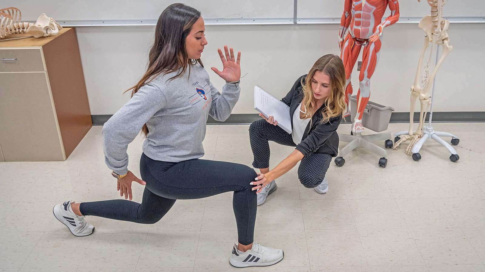 Wellness student assessing another student lunging 